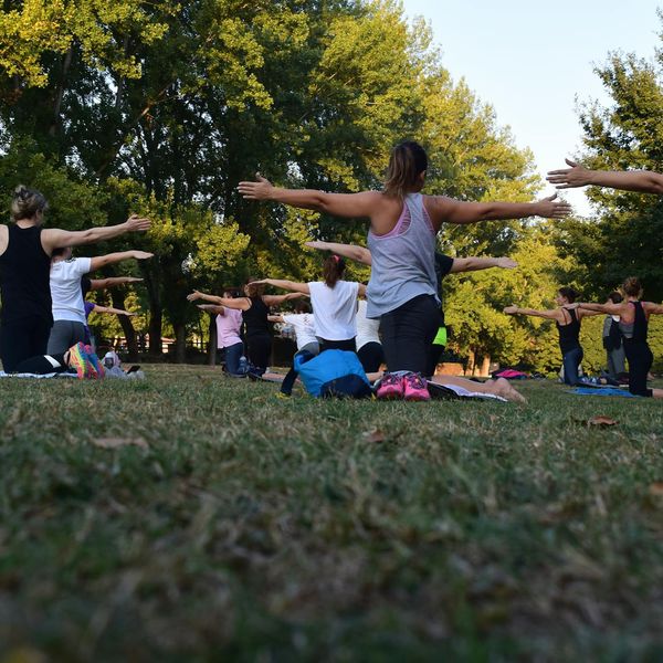 Diverse group of people smiling during an outdoor yoga class.