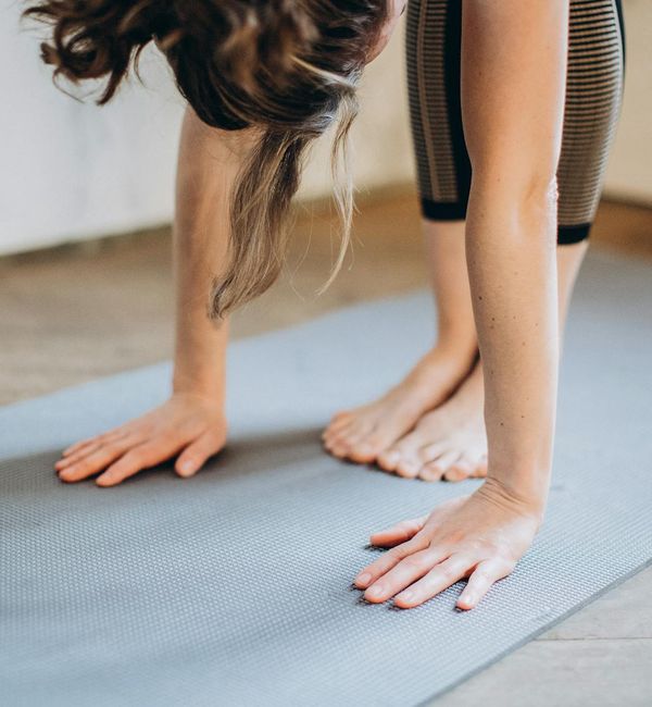 Person stretching on a yoga mat, demonstrating flexibility and strength.